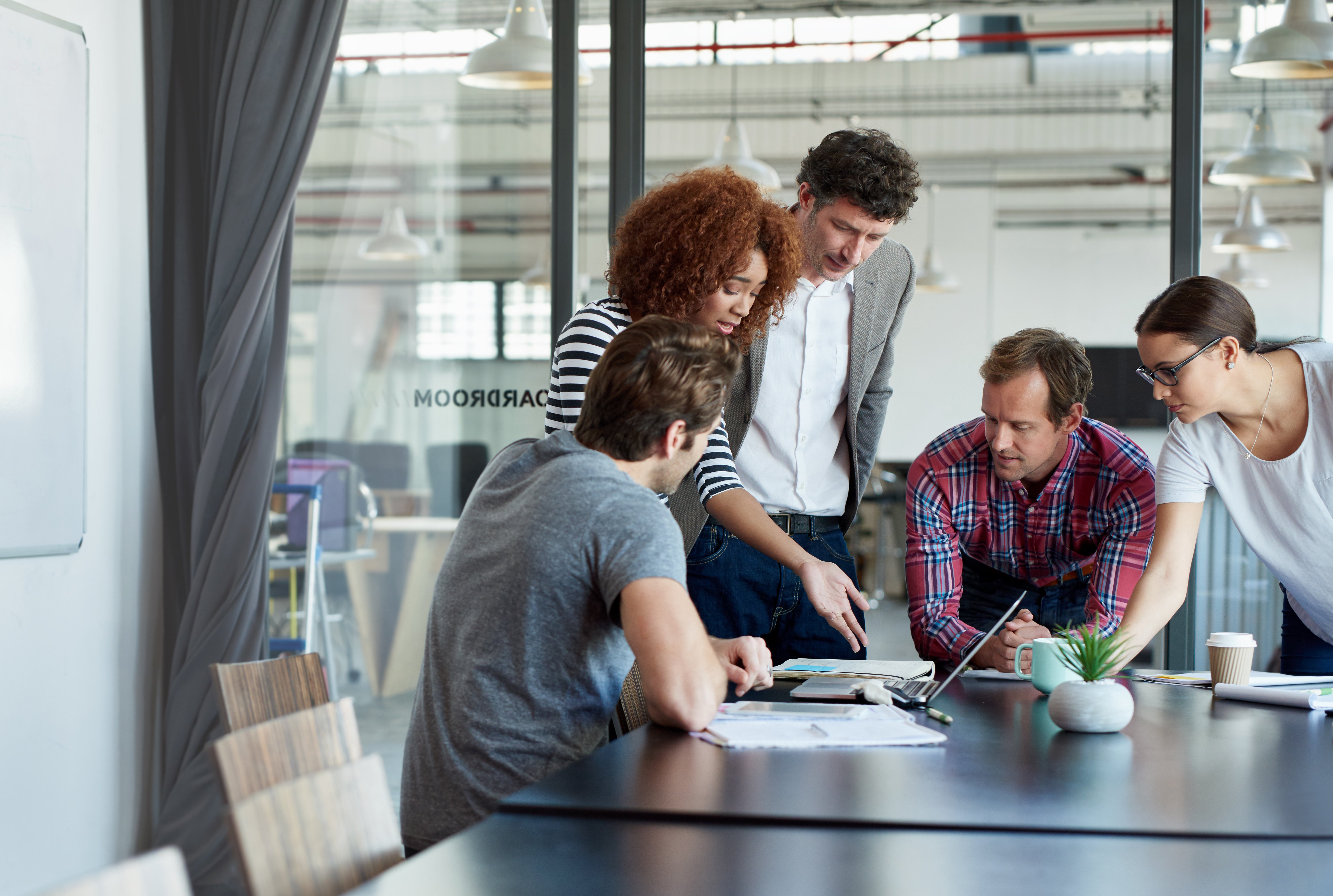 Group of people working at a table in a meeting room in an office